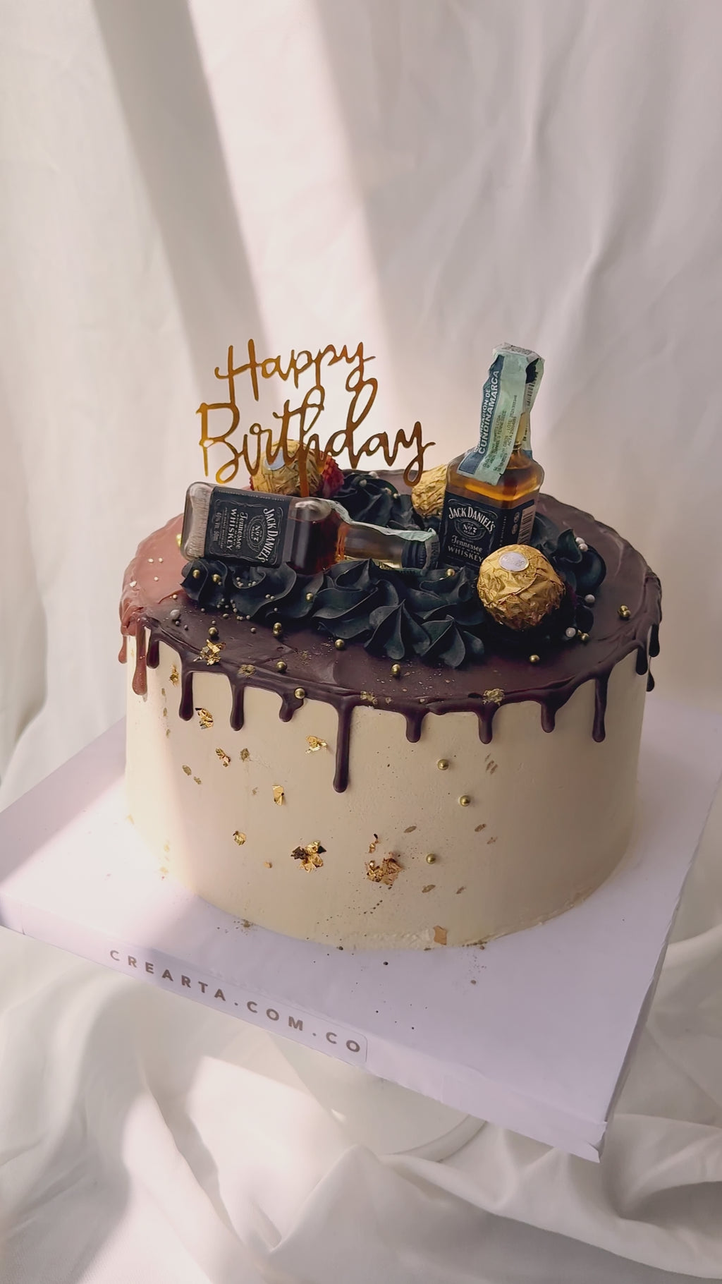Torta elegante con botellas y chocolates